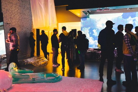 Silhouettes before a projection screen amid inflatable forms