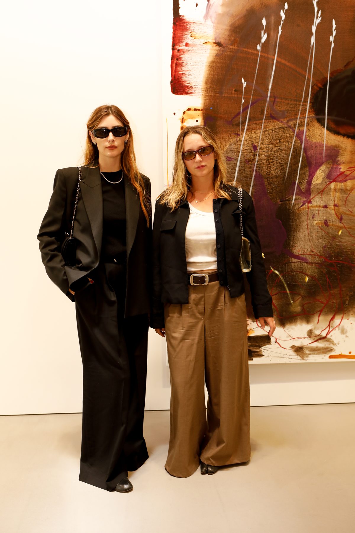 Two guests before a large abstract painting in a white gallery