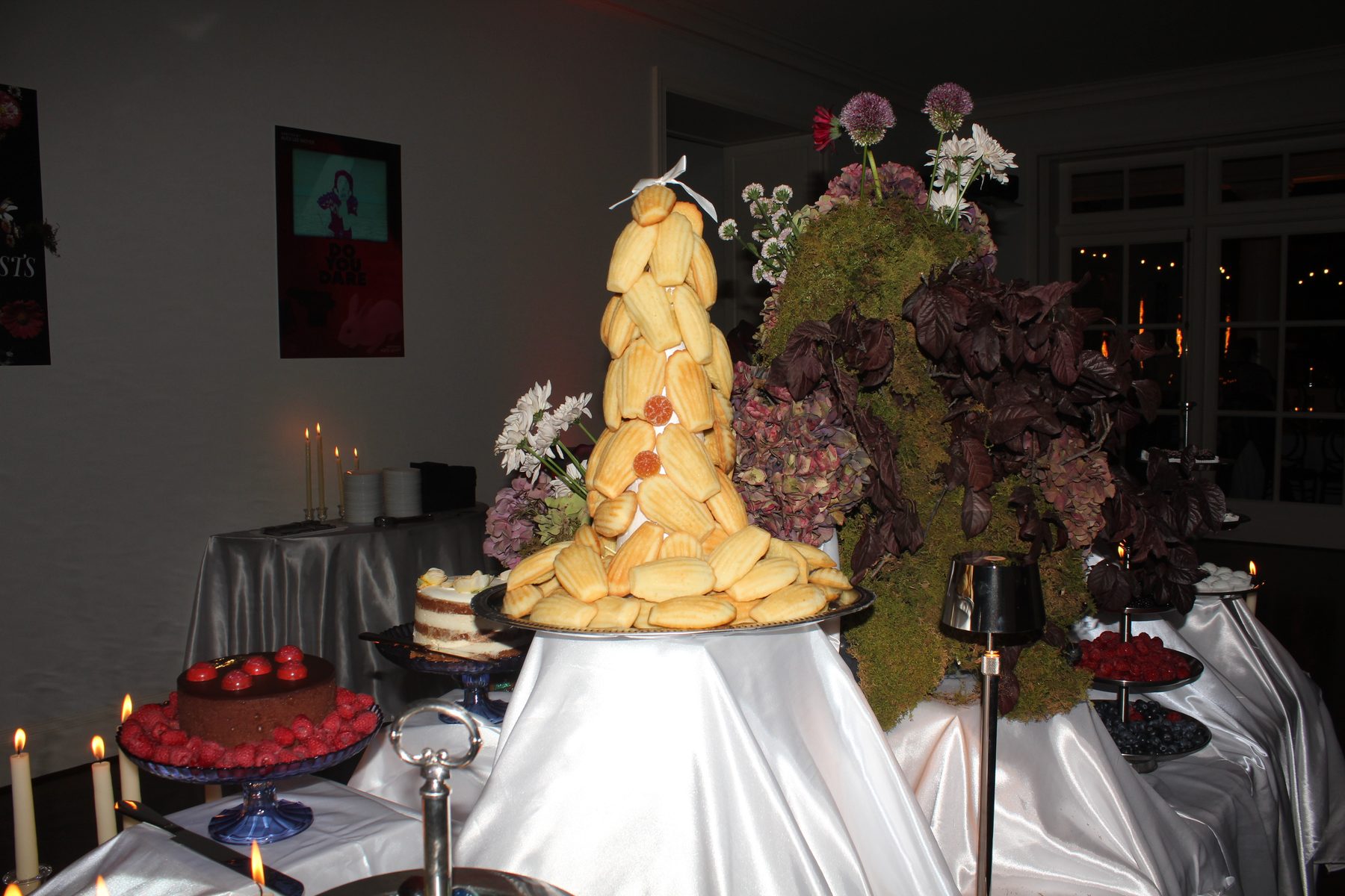 A towering madeleine dessert centerpiece with moss and florals
